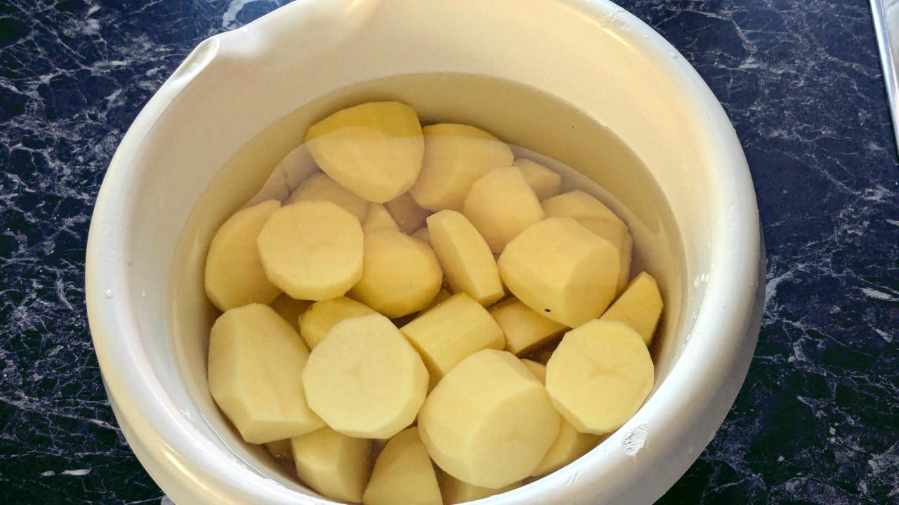 Kleine Kartoffelstücke liegen in einer hellen Schüssel im Wasser