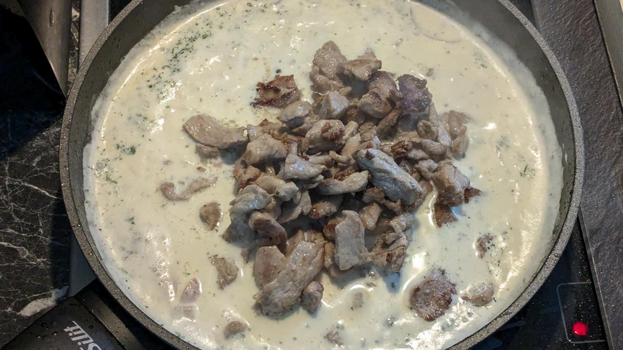 Filetstreifen in kochender Sahne in einer Pfanne